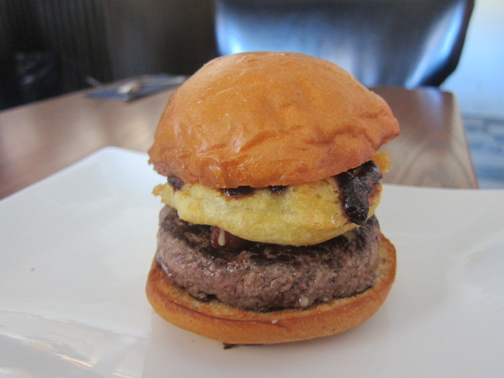 The Show Burger with Hak's BBQ sauce, onion strings, minced bacon and beer cheese